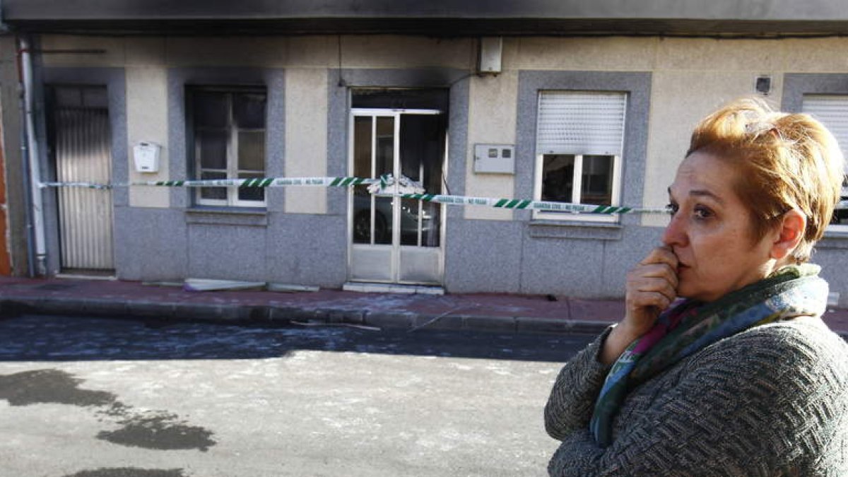 La hermana de la víctima, que vive en la primera planta, muestra su preocupación y pena por el siniestro ante la vivienda destrozada.