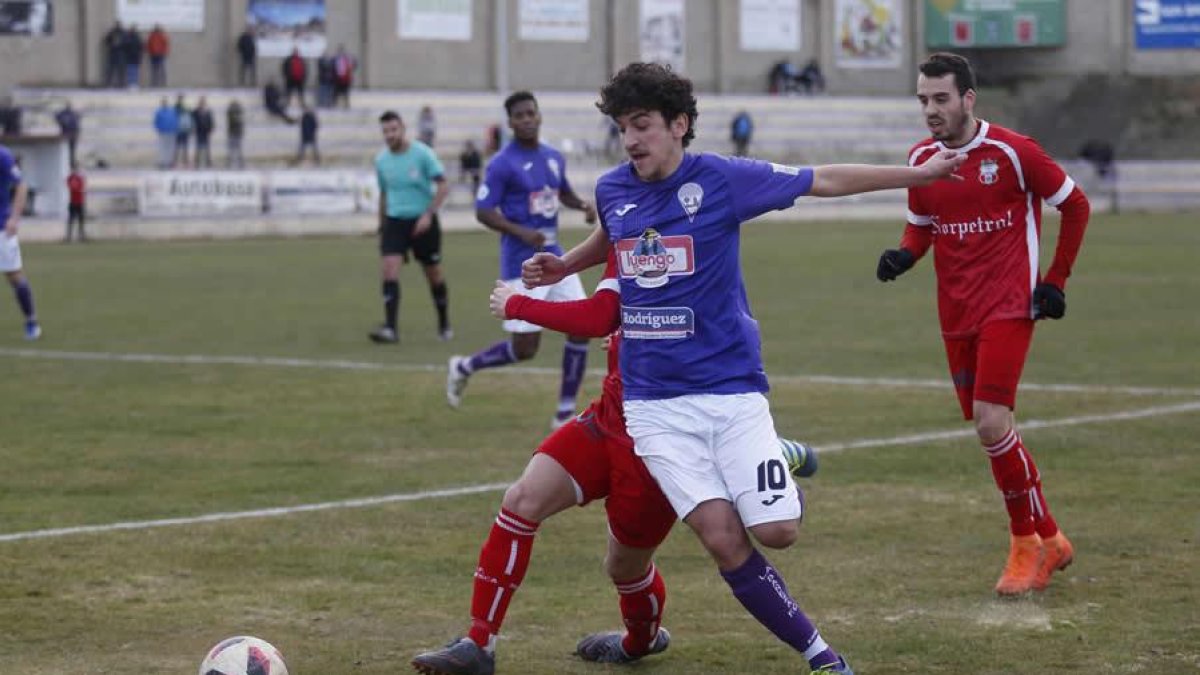 Adrián Rojo disputa un balón a un jugador rival.