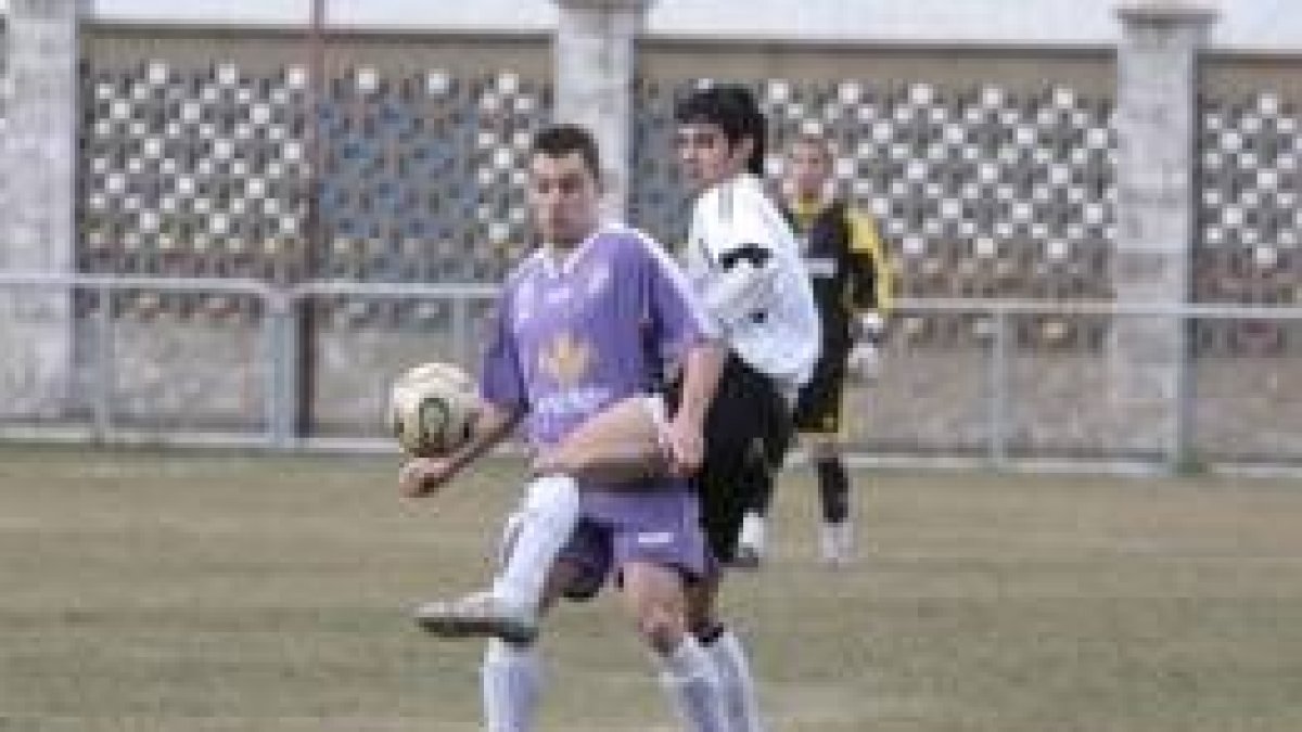 Fran, a la derecha, despeja el balón a pesar del agarrón de un jugador del equipo palentino