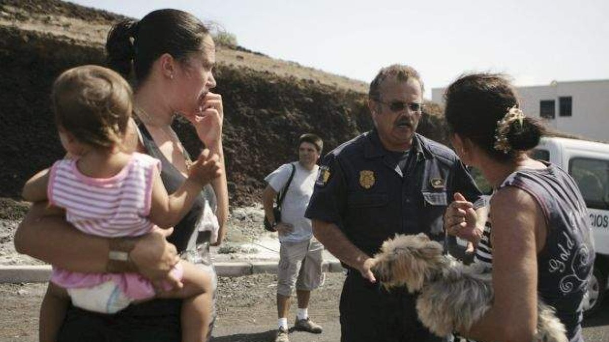 Una vecina de La Restinga, en la isla de El Hierro, conversa con un agente después de que las autoridades hayan pedido hoy al medio millar de habitantes de la localidad, que acudan al punto de reunión previsto en el Plan de Riesgo Volcánico ante la posibi