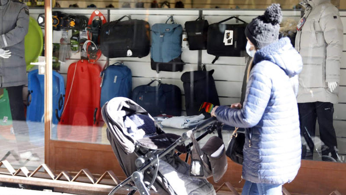 Una mujer pasea con el cochecito de un bebé por el centro de León. MARCIANO PÉREZ
