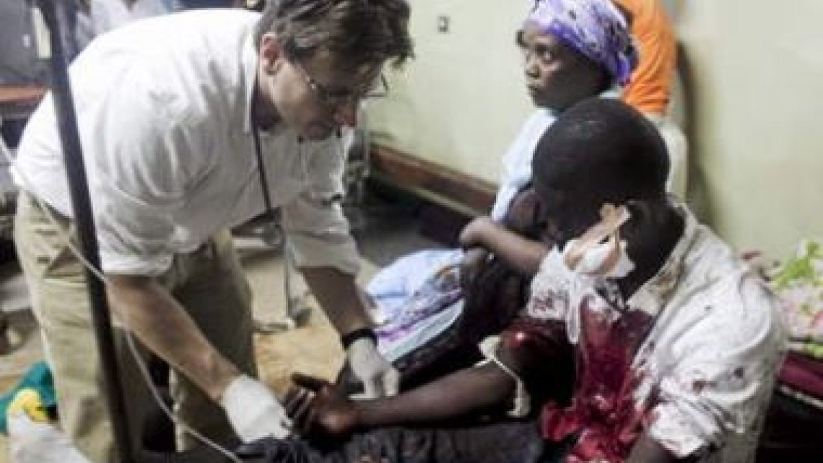 Un médico atiende en el hospital a un hombre herido por una de las explosiones en Kampala.