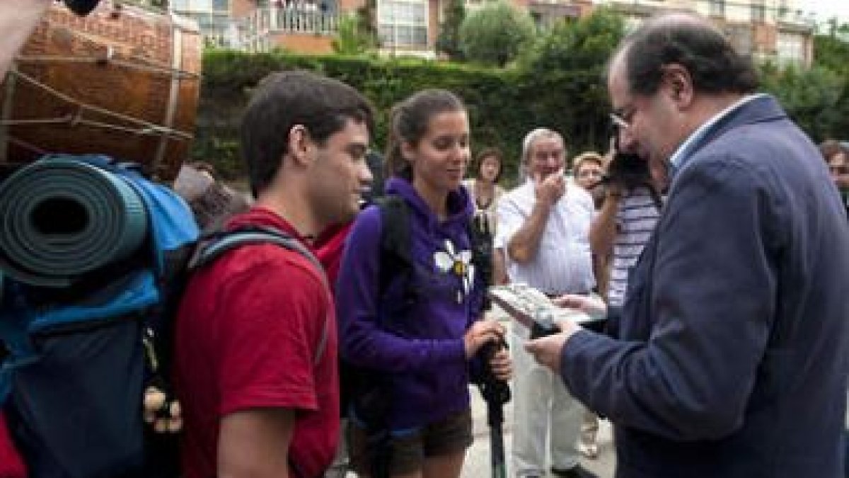El presidente Herrera conversa con unos peregrinos a su paso por Burgos.