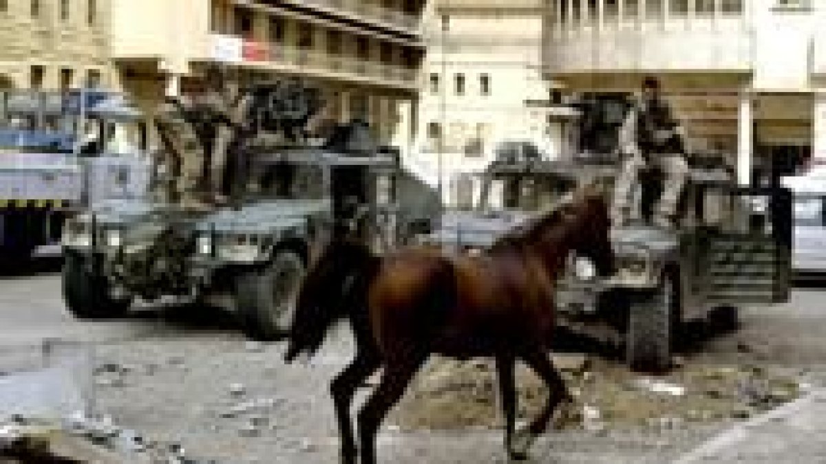Soldados iraquíes arrastran por las calles de Bagdad a un pura sangre árabe robado en los saqueos