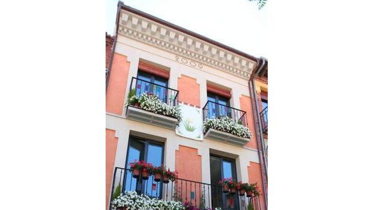 La fachada, además de flores, exhibe un estandarte con capilotes de Riaño y pequeñas vidrieras.