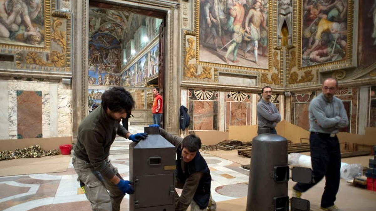 Trabajadores del Vaticano instalan estufas en la Capilla Sixtina.