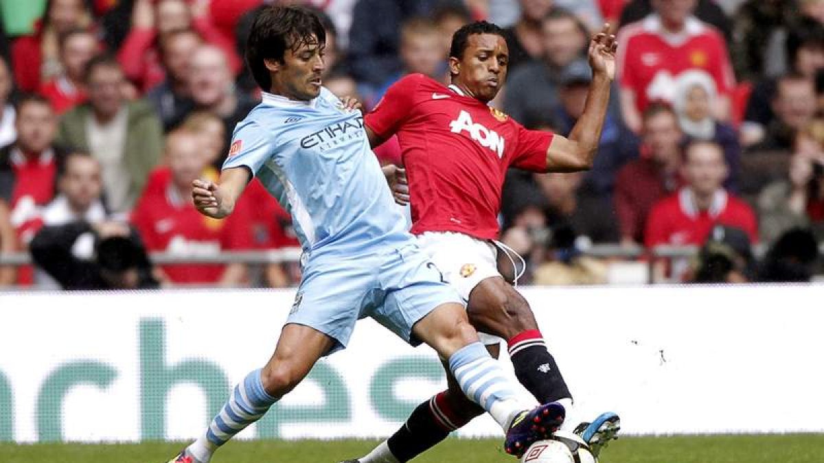 Silva, del Manchester City, lucha por el balón con Nani, futbolista del United.