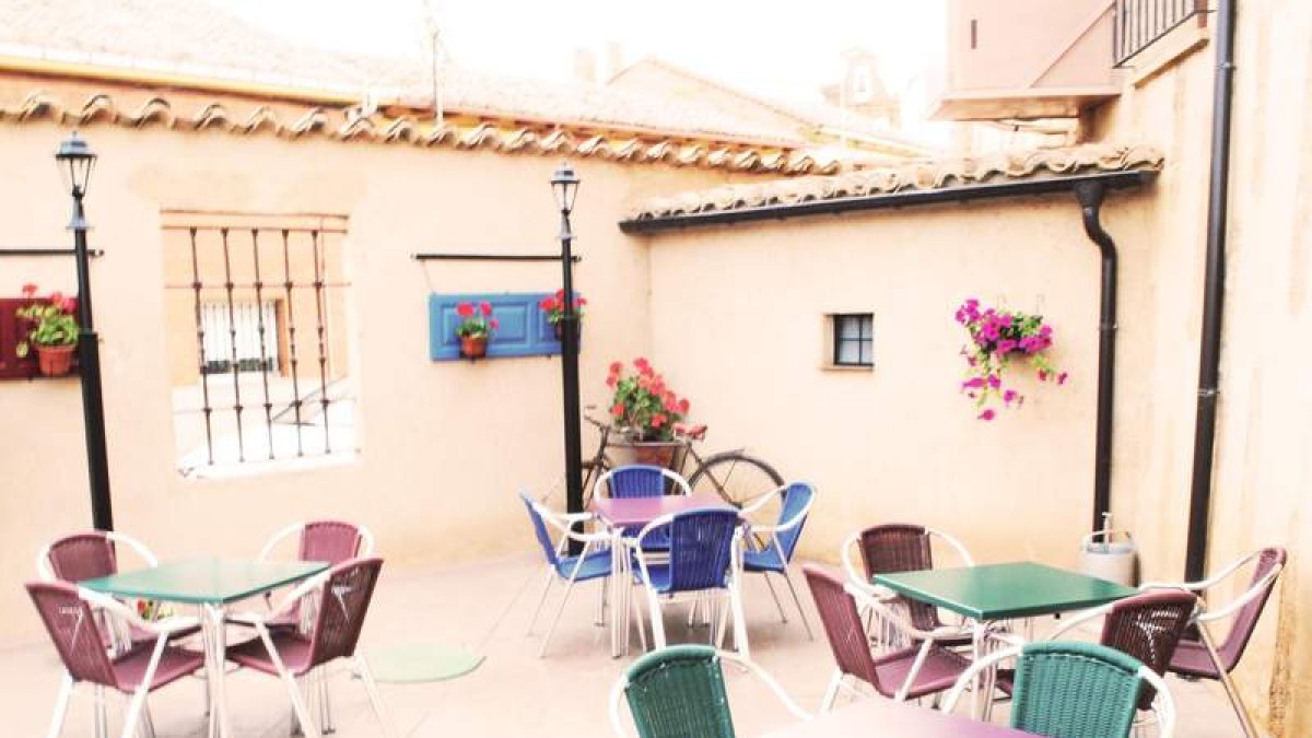 Arriba, el acogedorpatio de lacasa rural. Ala izquierda, uno de los dormitorios.