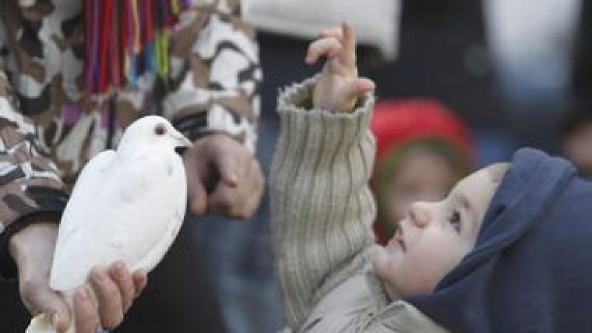 Un niño muestra el camino a una paloma para llegar a un cielo que parece más tranquilo que la tierra