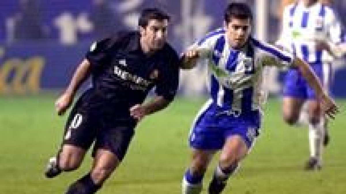 Valcarcel y Figo pugnan por el balón en un lance del partido disputado ayer en La Rosaleda