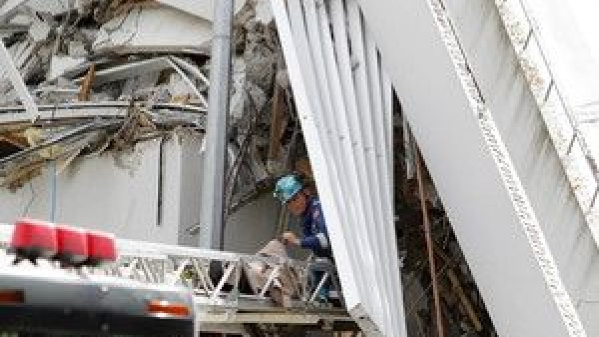 Equipos de salvamento trabajan en el rescate de personas atrapadas bajo un edificio.