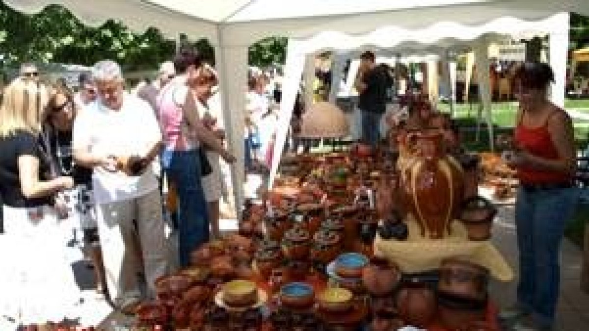 El alcalde saluda a los dos artistas locales invitados a la feria