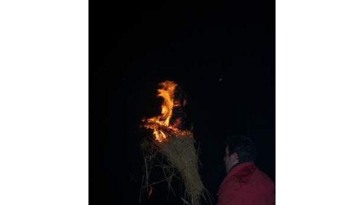 Un vecino con su pachizo en llamas, participa en el ritual.