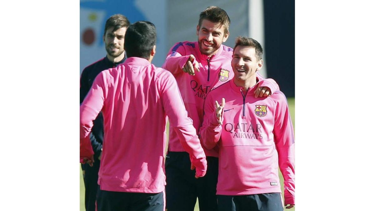 Piqué, junto a Messi y Suárez, de espalda, en el entrenamiento.