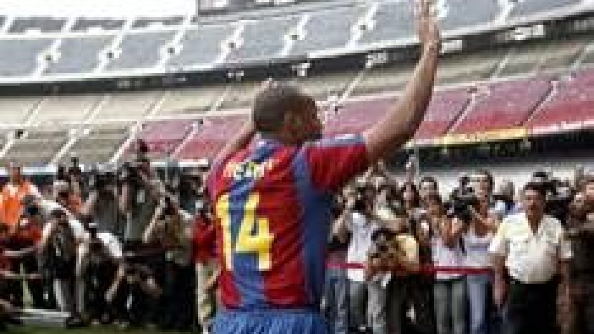 El delantero francés Thierry Henry saluda al público presente en el Camp Nou durante su presentación