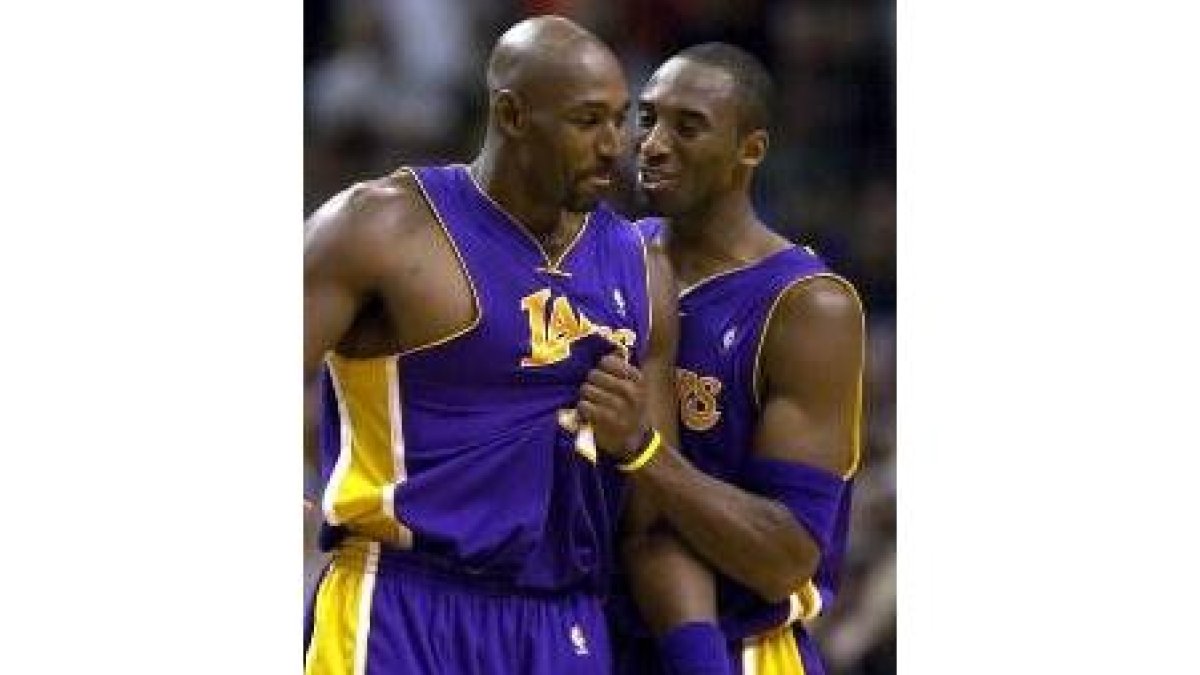 Kobe Bryant agarra y conversa con Karl Malone durante un partido