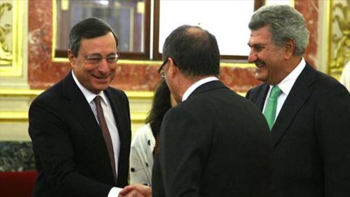 El presidente del BCE, Mario Draghi, saluda al gobernador del Banco de España, Luis María Linde.