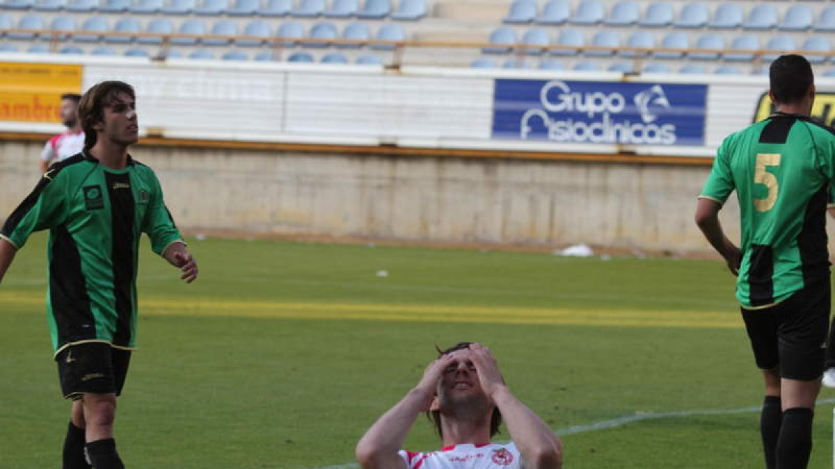 Oritz, en el medio de dos jugadores del Universidad de Oviedo, durante la última ronda del playoff.