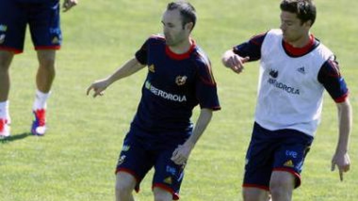 Iniesta y Xabi Alonso disputan un balón durante el entrenamiento de la selección española.