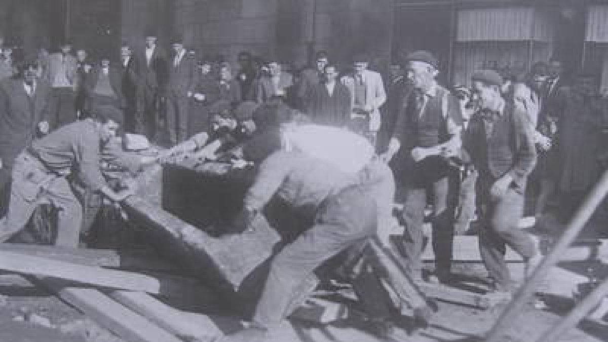 Unos obreros mueven un sarcófago de piedra, sacándolo de una fosa ante San Marcelo en 1950