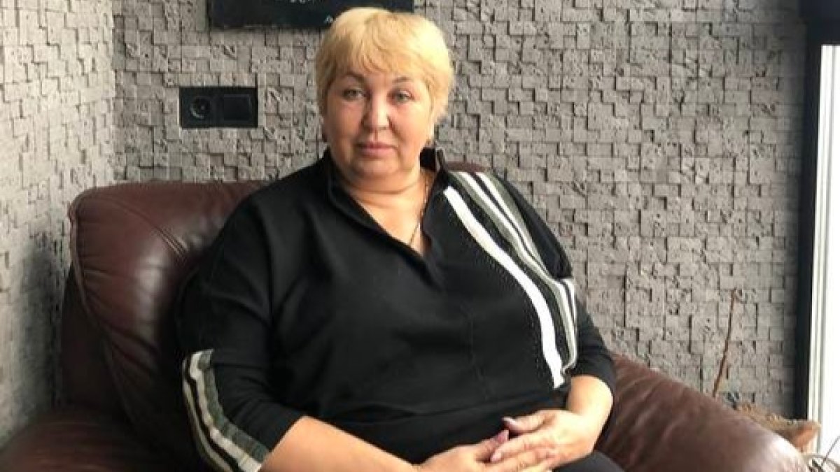 Natalia Kuderska delante de sus pinturas incluida una sobre la guerra. En la otra foto, su pasaporte. GERVASIO SÁNCHE