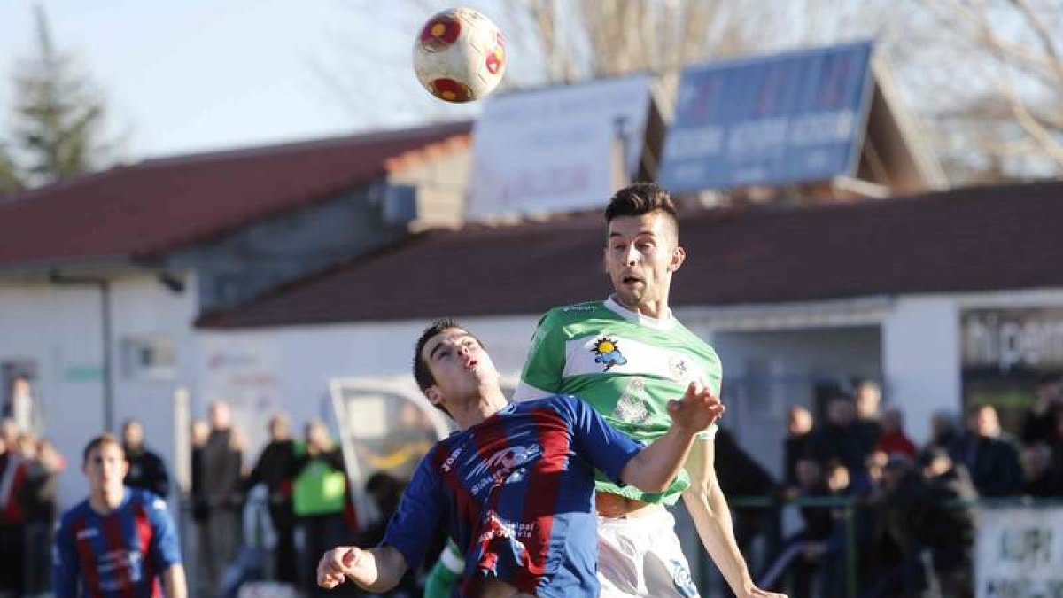 Ivi Vales remata de cabeza a pesar de la oposición de un jugador segoviano.