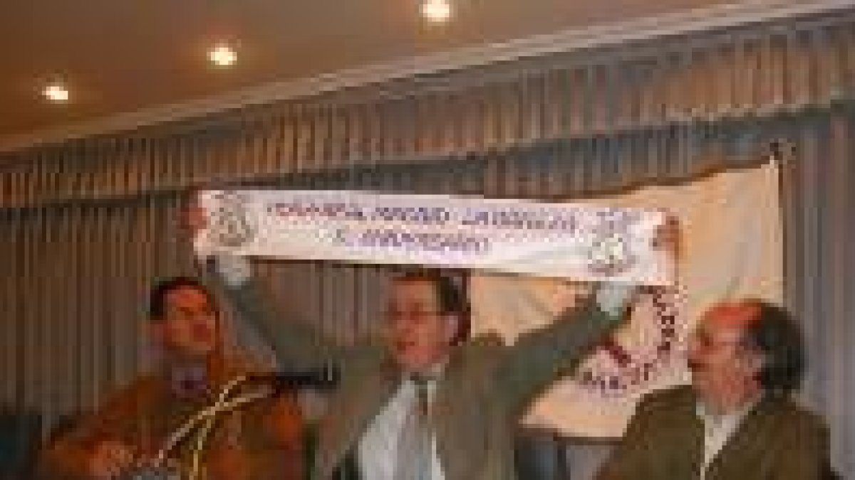 El presidente de la peña presenta la bufanda de las bodas de oro