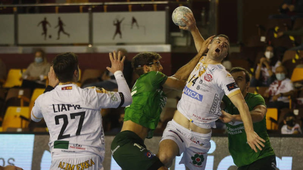 Milosavljevic se dispone a lanzar ante la portería del BM Logroño. En la acción Serradilla intenta frenar al central serbio del Abanca Ademar. FERNANDO OTERO