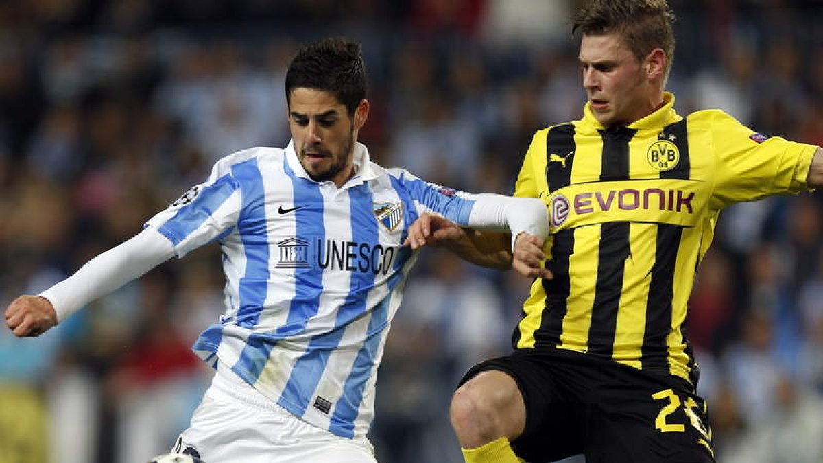 El jugador del Málaga Isco se dispone a chutar el balón ante el defensa polaco del Borussia de Dortmund, Lukasz Pisczek.