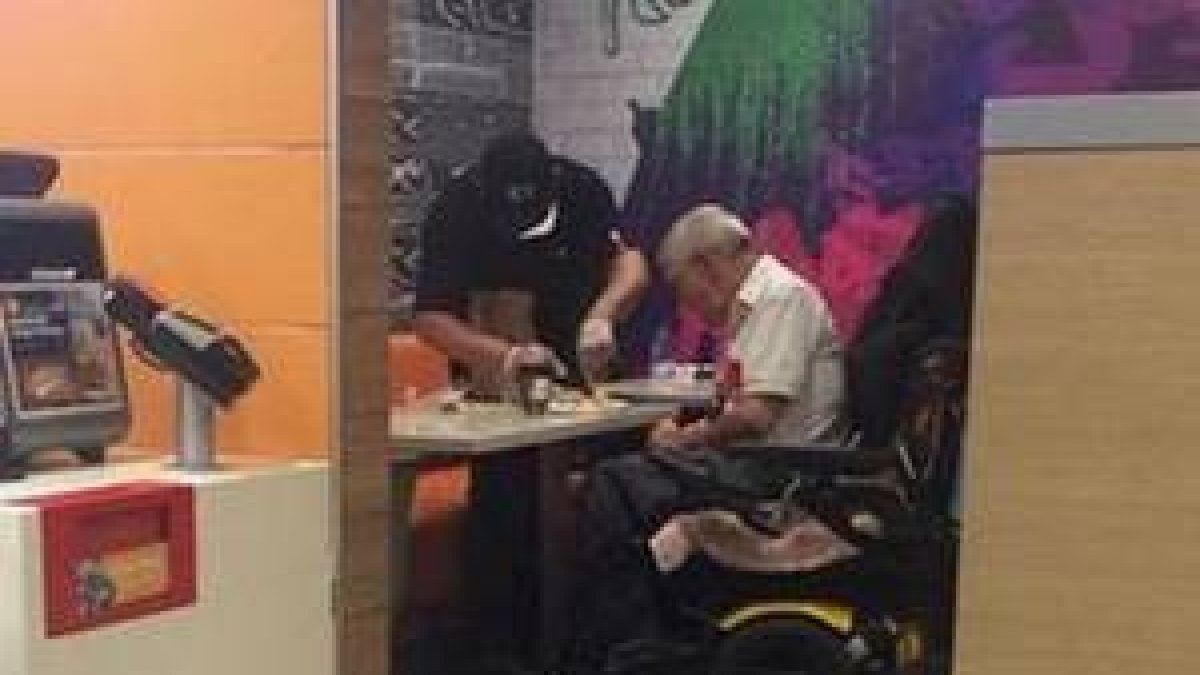 El empleado conocido como 'Kenny', mientras ayuda a un discapacitado.