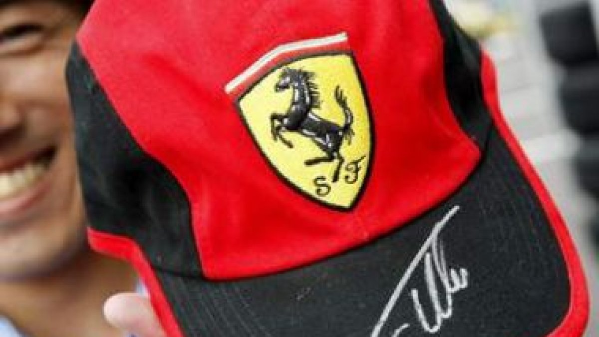 Un fan japonés con la gorra de Ferrari y la firma de Alonso.