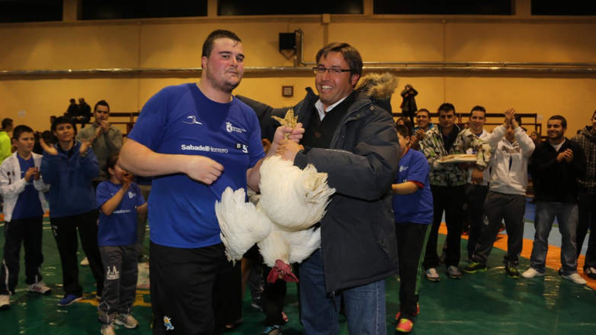 Abel Isaí Cabero recibe del diputado de Deportes, Emilio Orejas, el gallo que reconoce la tercera victoria consecutiva de la Ribera en el corro más clásico.