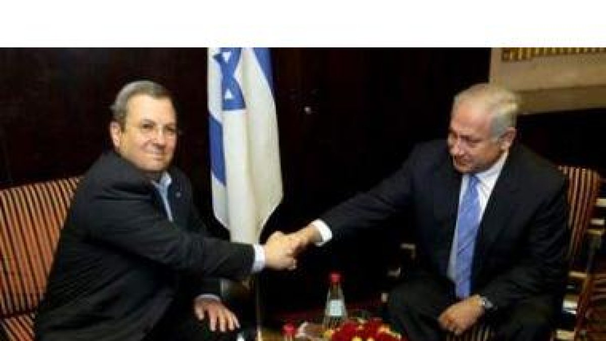 Netanyahu (d), estrecha la mano del líder del partido laborista, Ehud Barak, durante su reunión de a