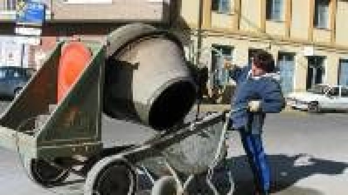 Una alumna vacía el agua de la hormigonera en una carretilla