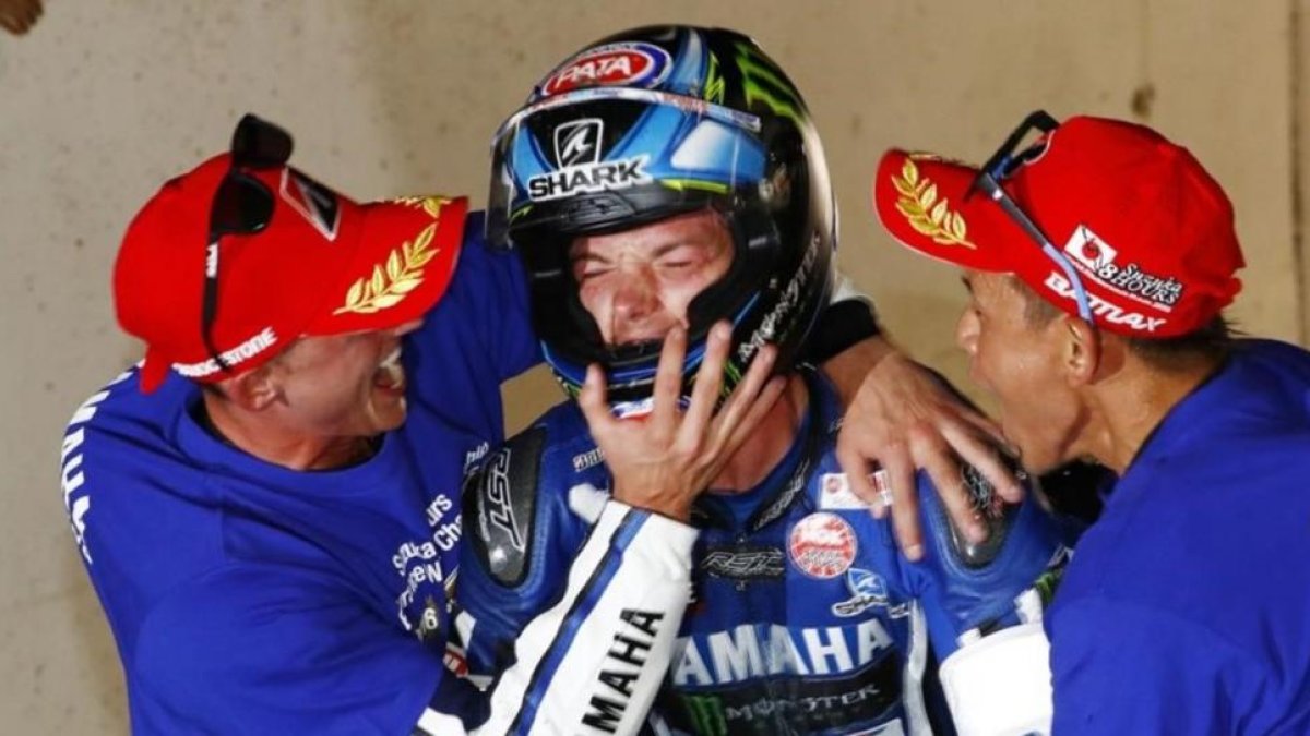 Pol Espargaró abraza a Alex Lowes ante la mirada de Katsuyuki Nakasuga.