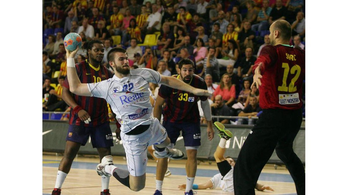El pivote Leonardo Almeida lanza a la portería defendida por Saric durante el partido que enfrentó al Ademar y el Barcelona en el Palau.