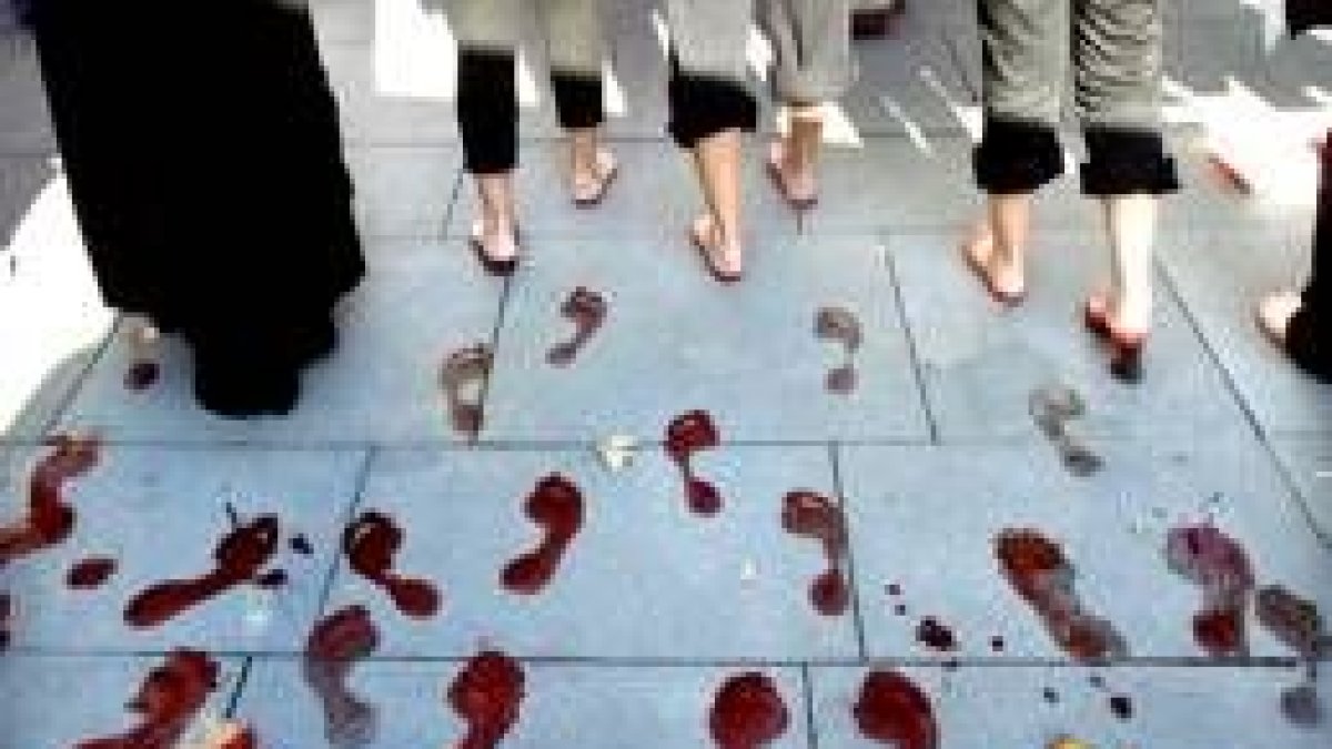 Unas mujeres dejan las huellas de sus pies teñidos durante la manifestación celebrada en Sevilla