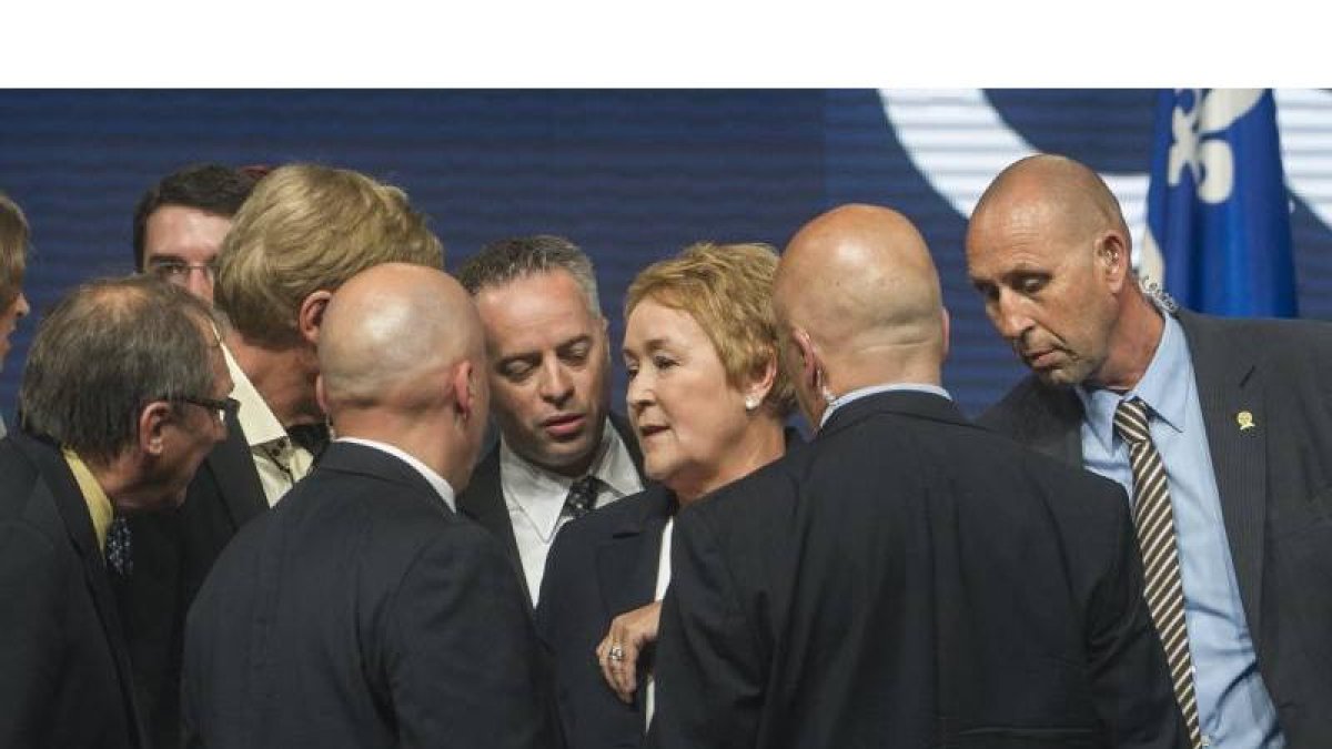 La policía escolta a Marois, durante su discurso de la victorial, en Montreal.