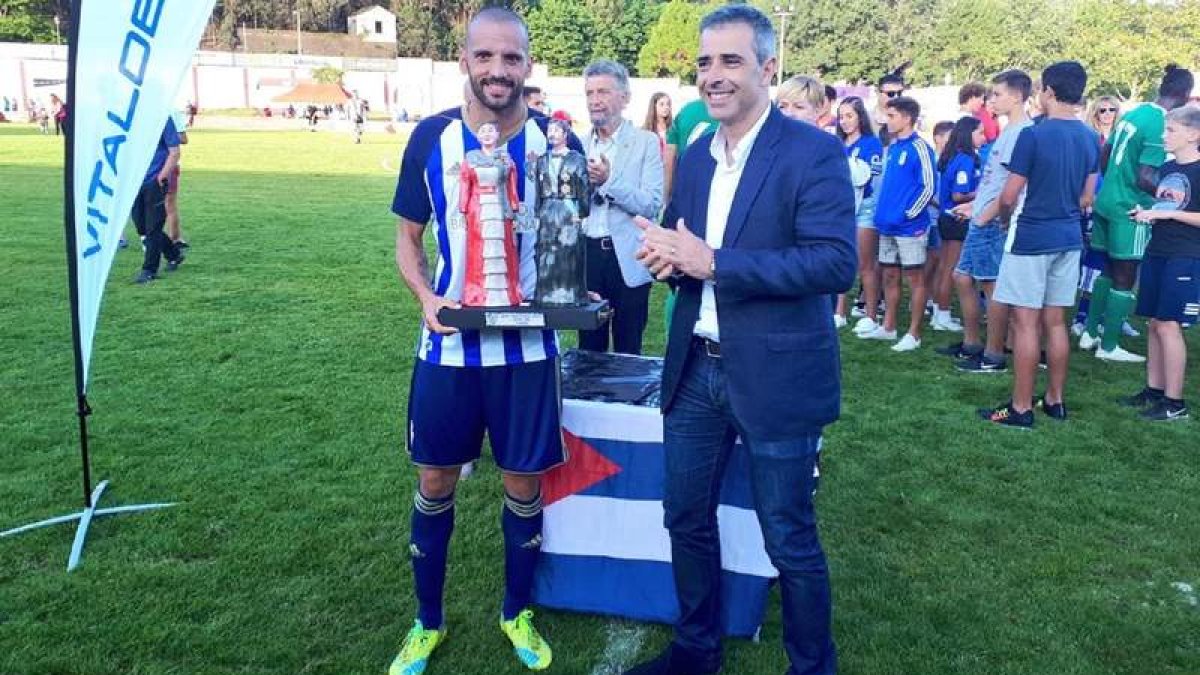 El capitán de la Deportiva, Yuri, recibió el trofeo Emma Cuervo tras vencer al Real Oviedo en el partido disputado en Navia. SDP