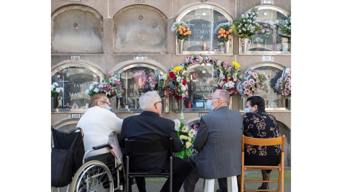 Una familia deposita flores en un cementerio de Barcelona el 1 de noviembre. MARTA PÉREZ