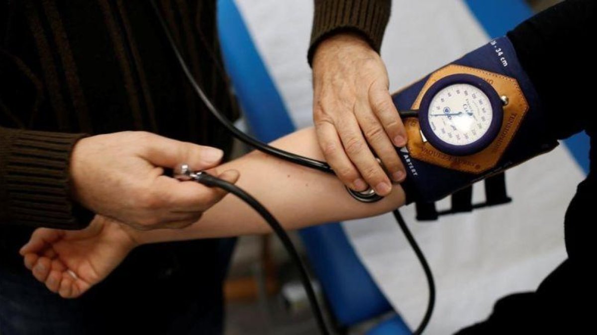 Un médico toma la presión a un paciente.