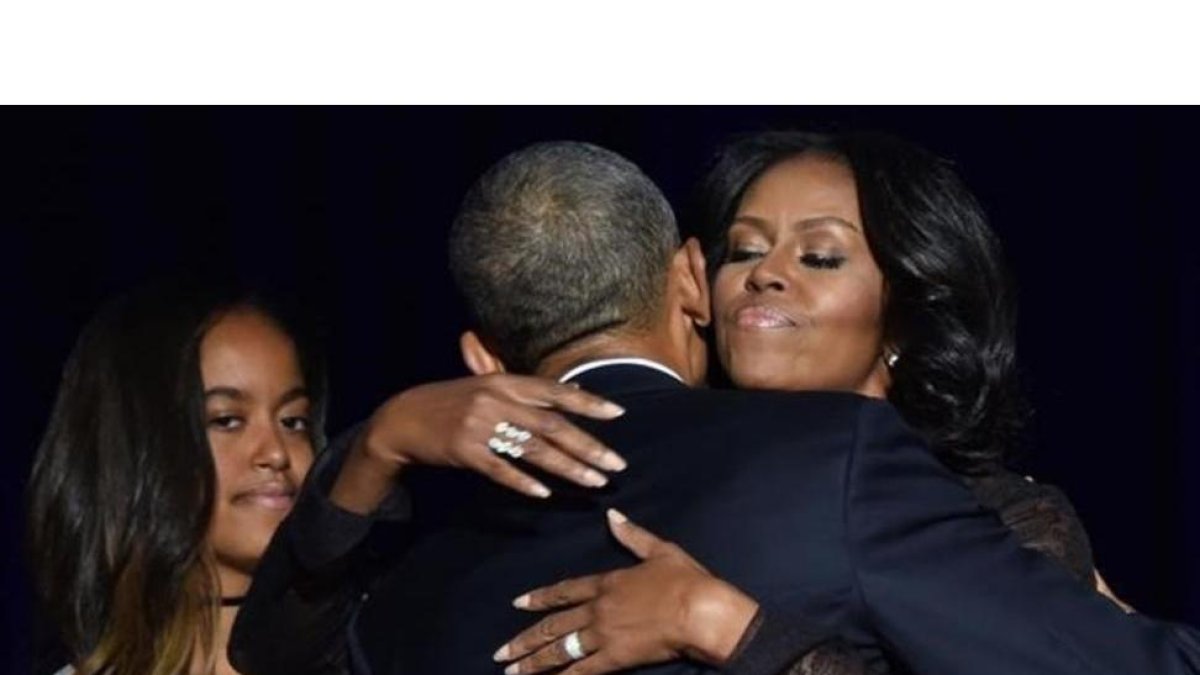 Obama abraza a su mujer, Michelle, en presencia de su hija Malia después de su discurso de despedida en Chicago.