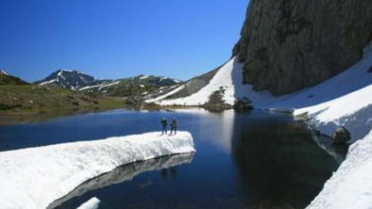 Dos miembros del grupo ecologista Filón Verde se dejan fotografiar sobre la barra de hielo de Las Ve
