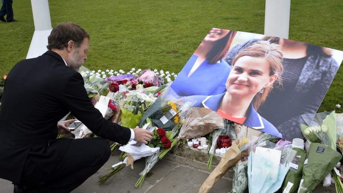 Un hombre deposita flores junto a una foto de Jo Cox. HANNAH MCKAY