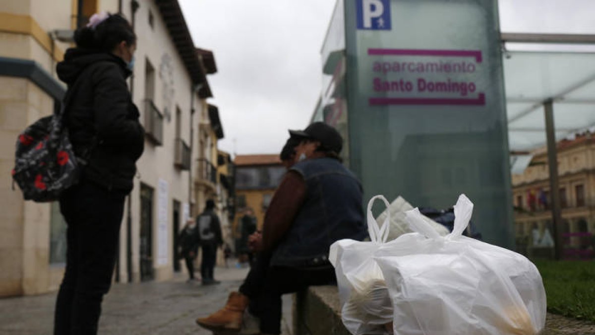 Personas comiendo tras recoger la comida del Hogar de Caridad. F. Otero Perandones.