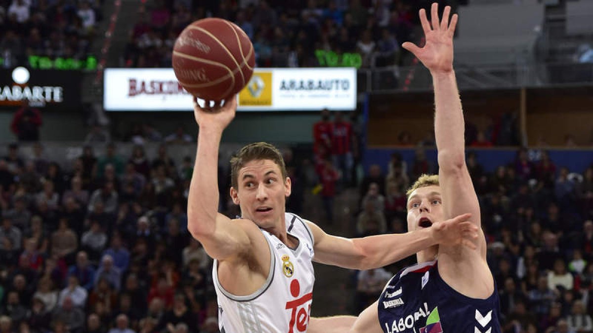 Jaycee Carroll intenta un pase ante el alero esloveno del Laboral Kutxa Jaka Bla.