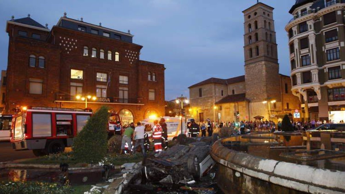 Imagen del taxi volcado en la fuente de Santo Domingo minutos después del accidente con policías y bomberos en el auxilio.