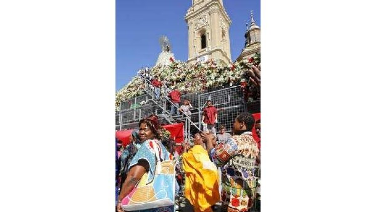 Varios turistas, durante la ofrenda floral del Pilar.