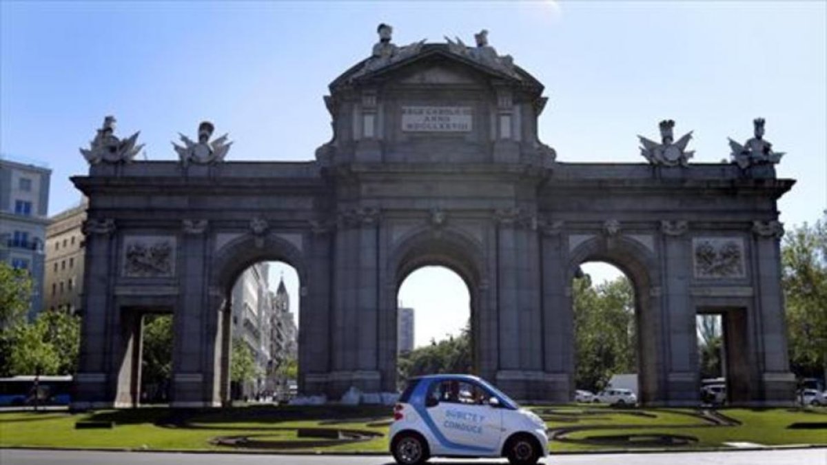 Un vehículo de Car2Go circula por la Puerta de Alcalá, en Madrid.