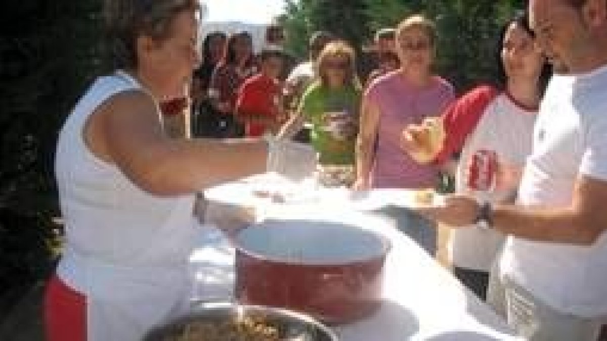 Una de las cocineras reparte las raciones de cordero elaborado a base de níscalos y boletus